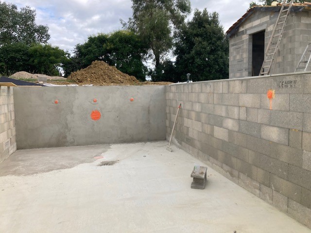 Structure béton d'une piscine avec murs banchés et réservations pour buses de refoulement