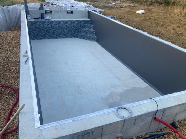 Piscine béton finie avant pose du liner, avec escalier intégré et margelles