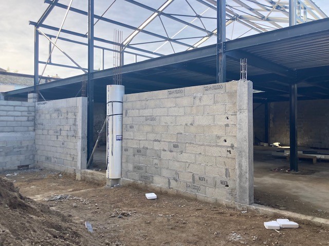 Murs en agglos et charpente métallique d'un bâtiment industriel en construction