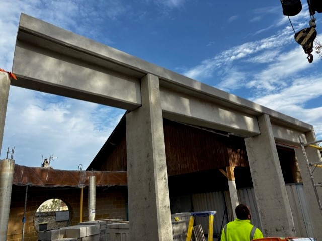 Portique béton préfabriqué levé à la grue sur chantier à Bouniagues
