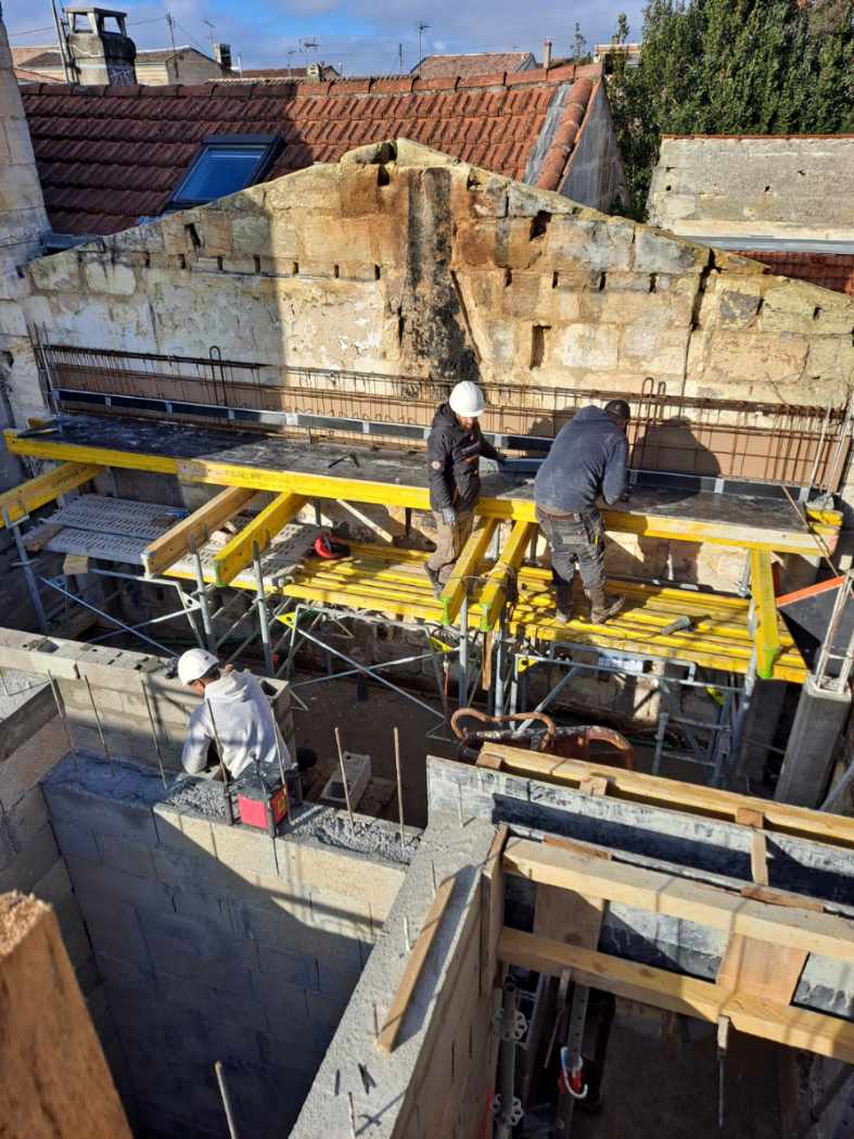 Coffrage d'un plancher béton en hauteur entre toits anciens en centre-ville