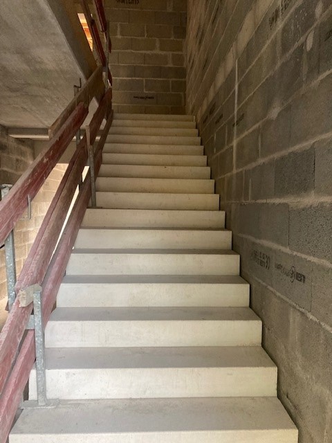 Escalier préfabriqué en béton dans une cage d'escalier en parpaings