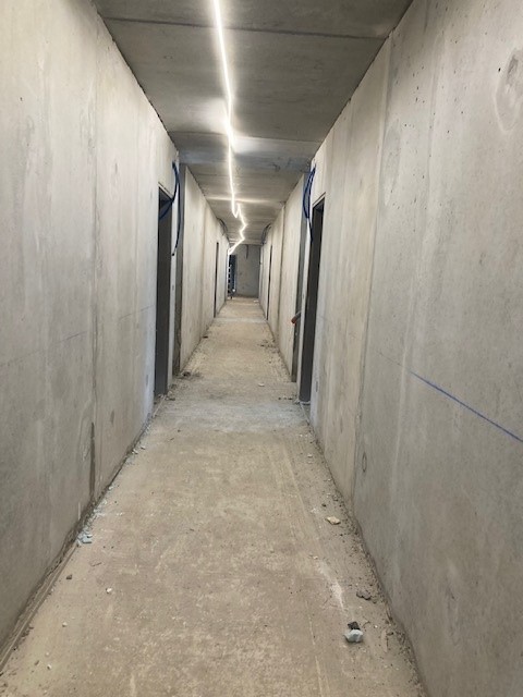 Couloir en sous-sol avec murs banchés en béton brut