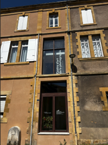 Façade en pierre d'un bâtiment ancien avec modification d'ouverture et nouvelle porte vitrée